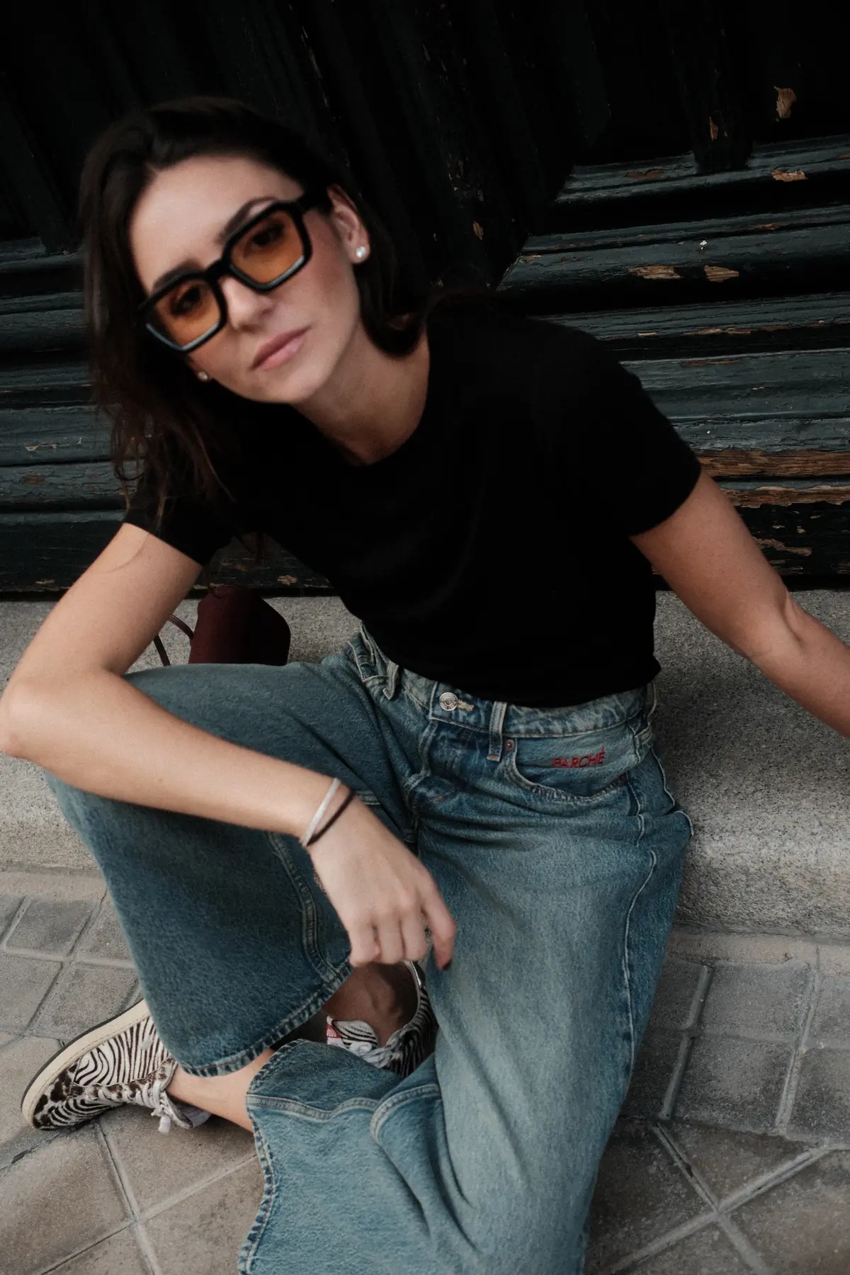 Parché Studio black trousers with a white monogram patch, worn with a navy blazer