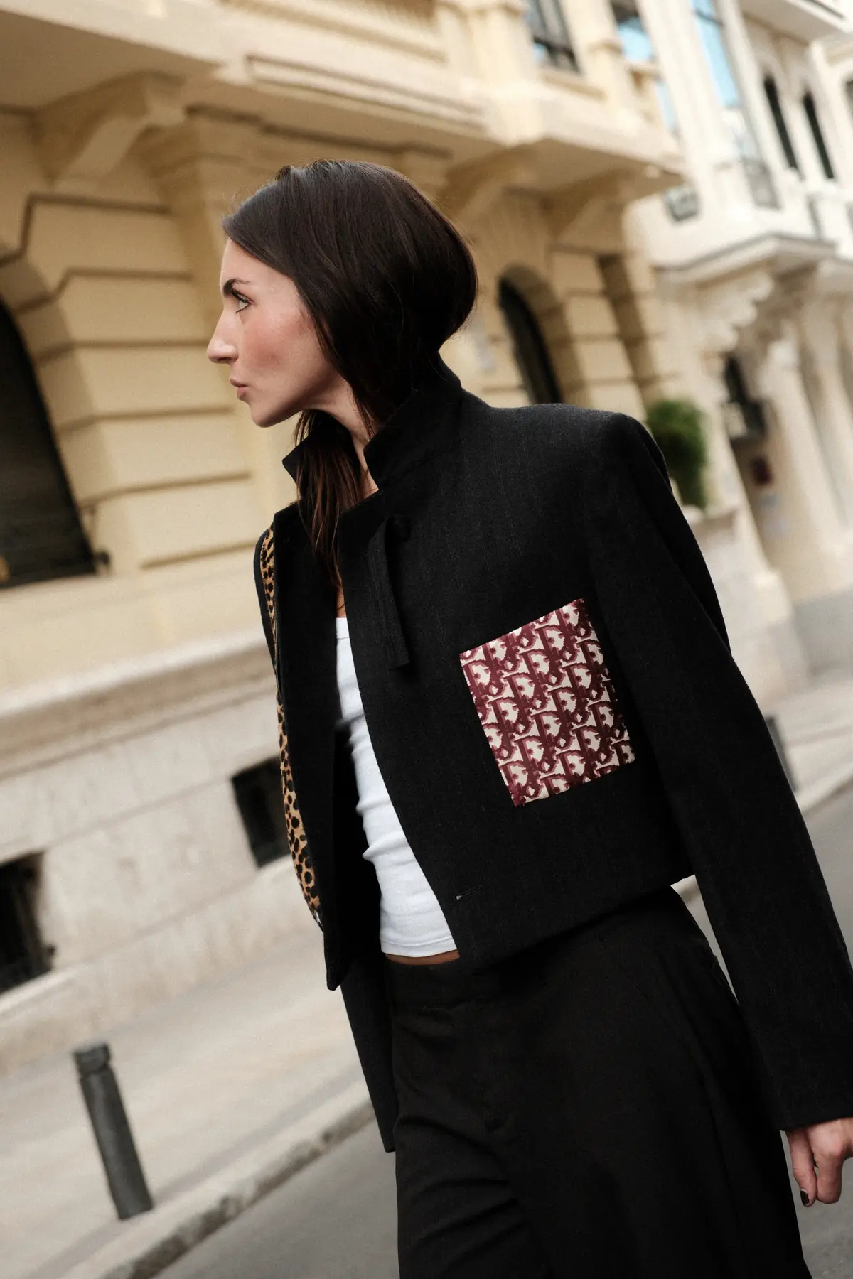 Parché Studio black blazer with a white monogram patch, worn with embroidered jeans